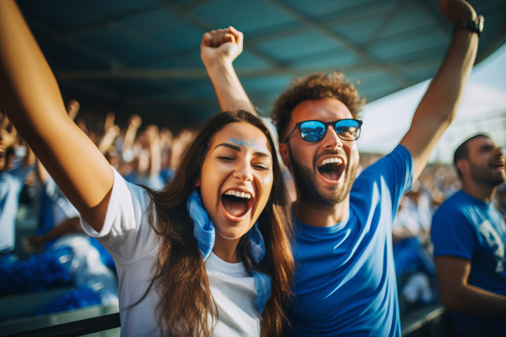 Two people are cheering at a sporting event.